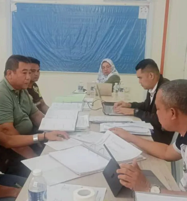 Auditors reviewing estate records at a table during the Lahad Datu audit